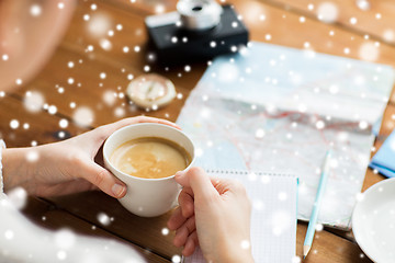 Image showing close up of hands with coffee cup and travel stuff