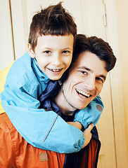 Image showing young handsome father with his son fooling around at home, lifestyle people concept