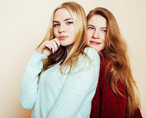 Image showing Two young girlfriends in winter sweaters indoors having fun. Lif