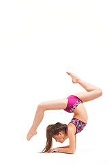 Image showing The teenager girl doing gymnastics exercises isolated on white background