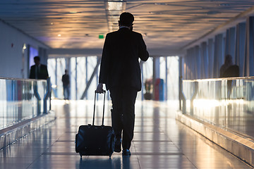 Image showing Businessman at airport corridor walking to departure gates.