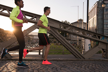 Image showing young multiethnic couple jogging in the city