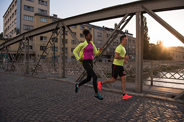 Image showing young multiethnic couple jogging in the city