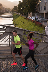 Image showing young multiethnic couple jogging in the city