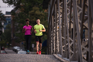 Image showing multiethnic couple jogging in the city