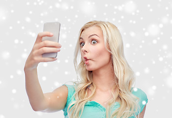 Image showing funny young woman taking selfie with smartphone