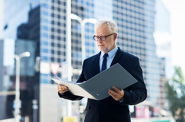 Image showing senior businessman with ring binder folder in city