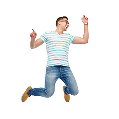 Image showing happy young man jumping in air