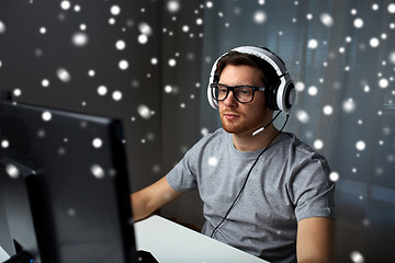 Image showing man in headset playing computer video game at home