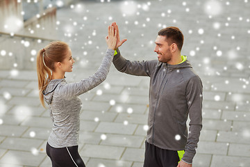 Image showing happy couple giving high five outdoors