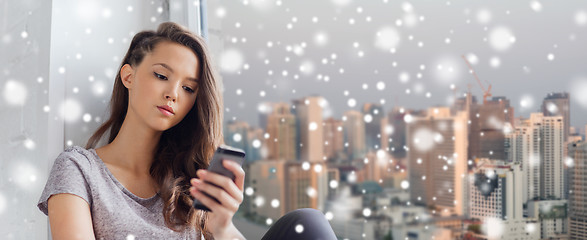 Image showing sad pretty teenage girl with smartphone texting