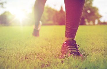 Image showing close up of exercising woman legs on grass in park