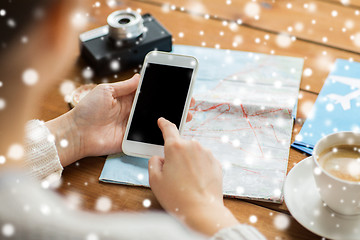 Image showing close up of traveler hands with smartphone and map