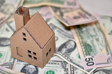 Image showing Miniature paper made house stand on  money