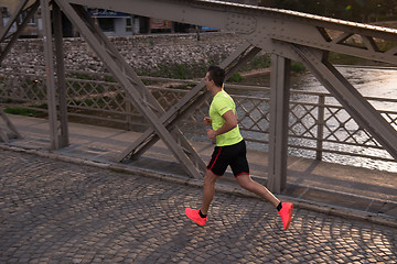 Image showing a young man jogging in the city