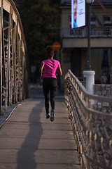 Image showing african american woman running across the bridge