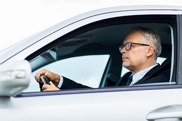 Image showing happy senior businessman driving car