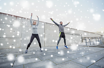 Image showing happy man and woman jumping outdoors