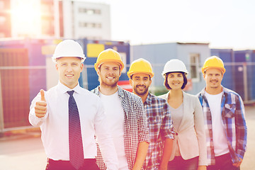 Image showing group of smiling builders in hardhats outdoors