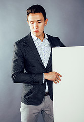 Image showing young pretty business man standing on white background, modern hairstyle, posing emotional, lifestyle people concept