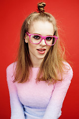 Image showing young pretty emitonal posing teenage girl on bright red background, happy smiling lifestyle people concept