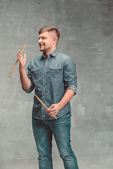 Image showing Man holding two drumsticks over gray background