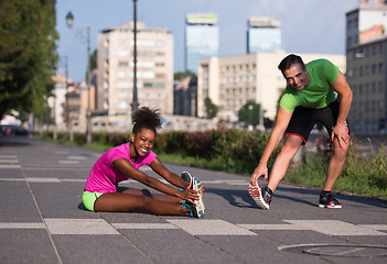 Image showing jogging couple warming up and stretching in the city