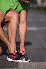 Image showing Young athlete, runner tie shoelaces in shoes