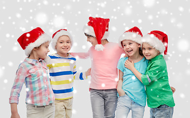 Image showing happy little children in santa hats hugging