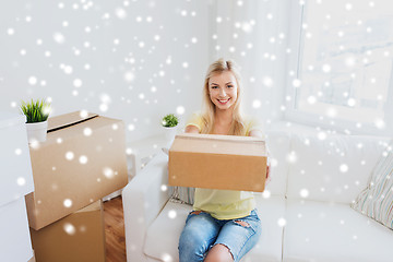 Image showing smiling young woman with cardboard box at home