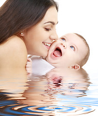 Image showing playful mama with happy baby in water