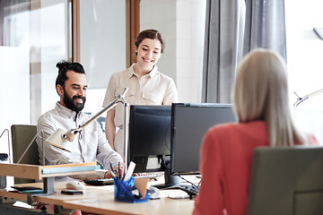 Image showing happy creative team with computers in office