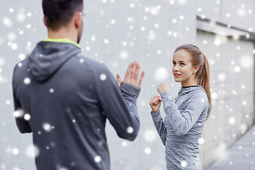 Image showing happy woman with coach working out strike outdoors