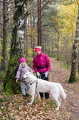 Image showing Granny with her granddaughter and a dog walk in autumn Park  