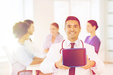 Image showing happy doctor with tablet pc over team at clinic