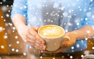 Image showing close up of hands with latte art in coffee cup