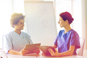 Image showing happy doctors with tablet pc meeting at hospital