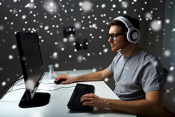 Image showing man in headset playing computer video game at home