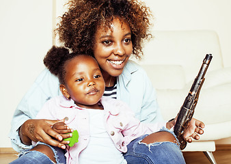 Image showing adorable sweet young afro-american mother with cute little daughter, hanging at home, having fun playing smiling, lifestyle people concept, happy smiling modern family