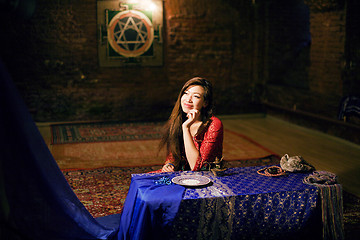 Image showing young pretty asian girl in bright colored interior on carpet view