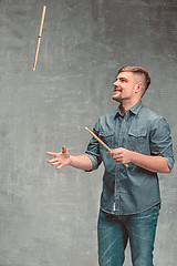 Image showing Man holding two drumsticks over gray background