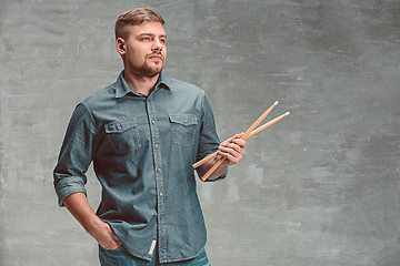 Image showing Man holding two drumsticks over gray background