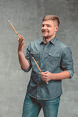 Image showing Man holding two drumsticks over gray background