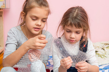 Image showing Two girls captivated bubbles burst inflatable packaging package