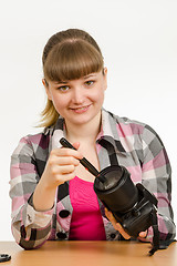 Image showing Photographer cleans front of the lens on the camera and looked into the frame