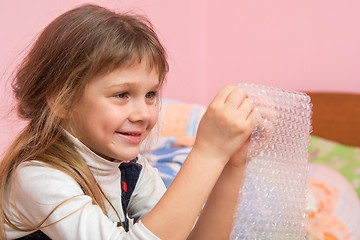 Image showing Girl eats balls on the wrapping paper