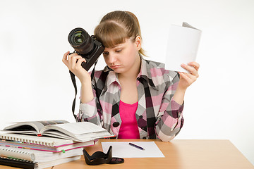 Image showing The girl reads the manuals and tutorials, trying to learn how to take pictures