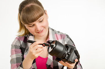 Image showing Photographer brush cleans the front of the lens on the camera