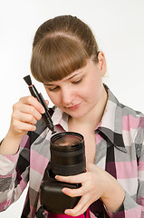 Image showing Photographer cleans front of the lens on the camera