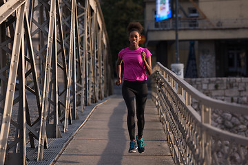 Image showing african american woman running across the bridge